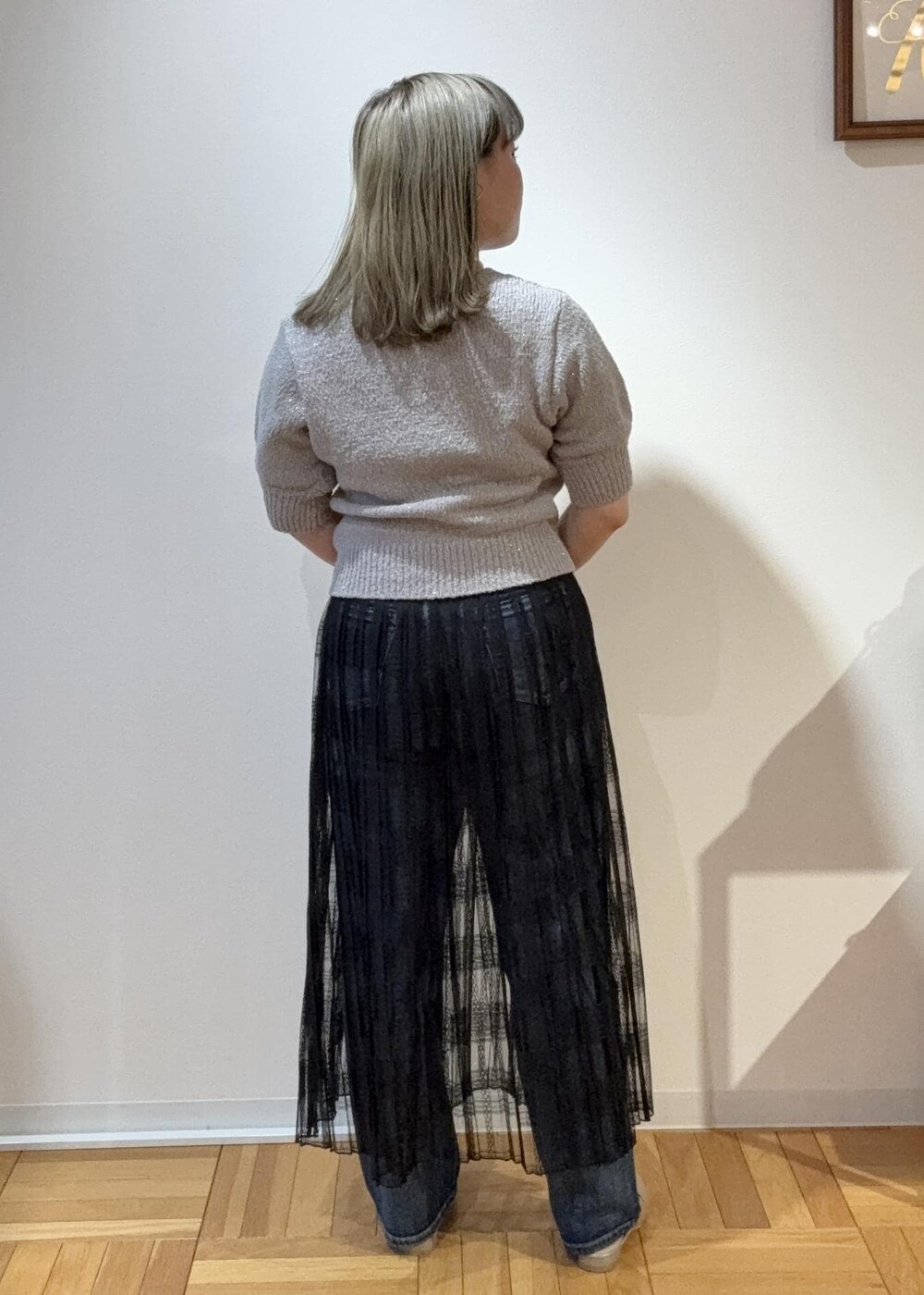 ブラック系のスカート、ベージュ系のボストンバッグ、グレー系のローファーを着用したレディースの春コーディネートの3枚目の写真