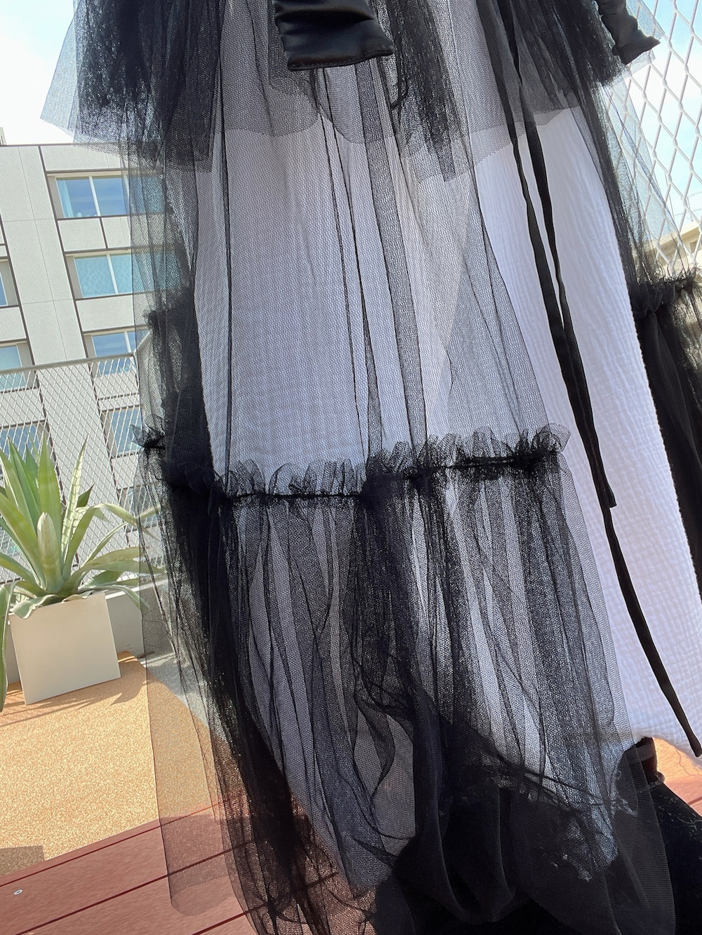 グレー系のブーツ、ブラック系のベスト、ブラック系のTシャツ/カットソーを着用したレディースの春コーディネートの4枚目の写真