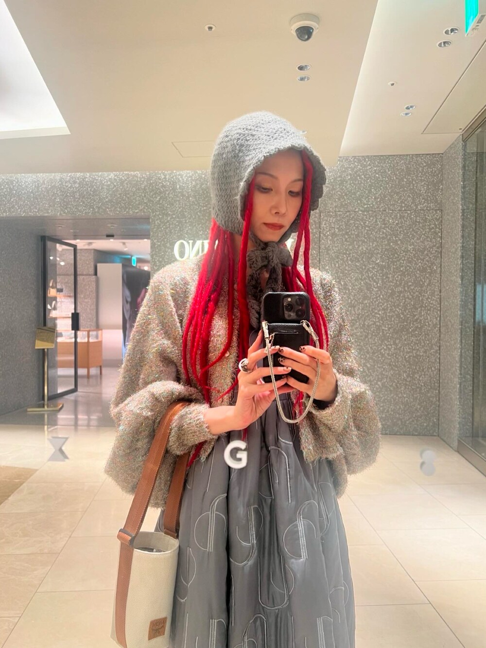 グレー系のワンピース、その他のカーディガン/ボレロ、グレー系のスニーカーを着用したレディースの春コーディネートの4枚目の写真