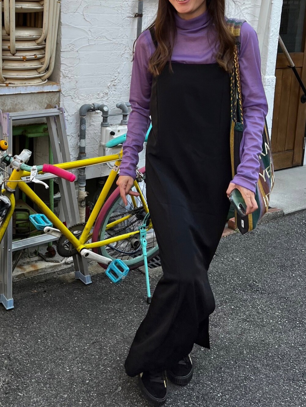 ブラック系のトートバッグ、ブラック系のスニーカー、ブラック系のキャミソールを着用したレディースの秋コーディネートの3枚目の写真