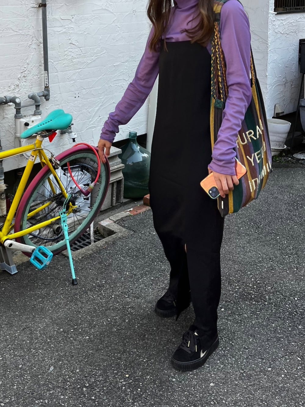 ブラック系のトートバッグ、ブラック系のスニーカー、ブラック系のキャミソールを着用したレディースの秋コーディネートの2枚目の写真