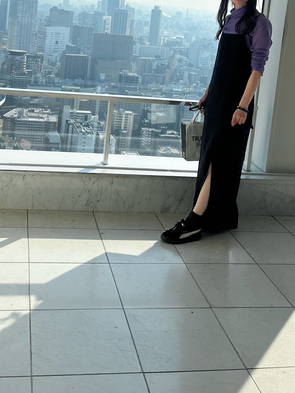 ブラック系のトートバッグ、ブラック系のスニーカー、ブラック系のキャミソールを着用したレディースの秋コーディネートの4枚目の写真