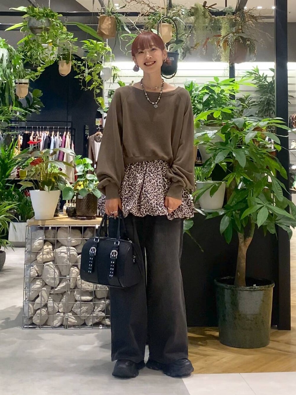 グレー系のデニムパンツ、ブラック系のローファー、ブラック系のボストンバッグを着用したレディースの秋コーディネートの3枚目の写真