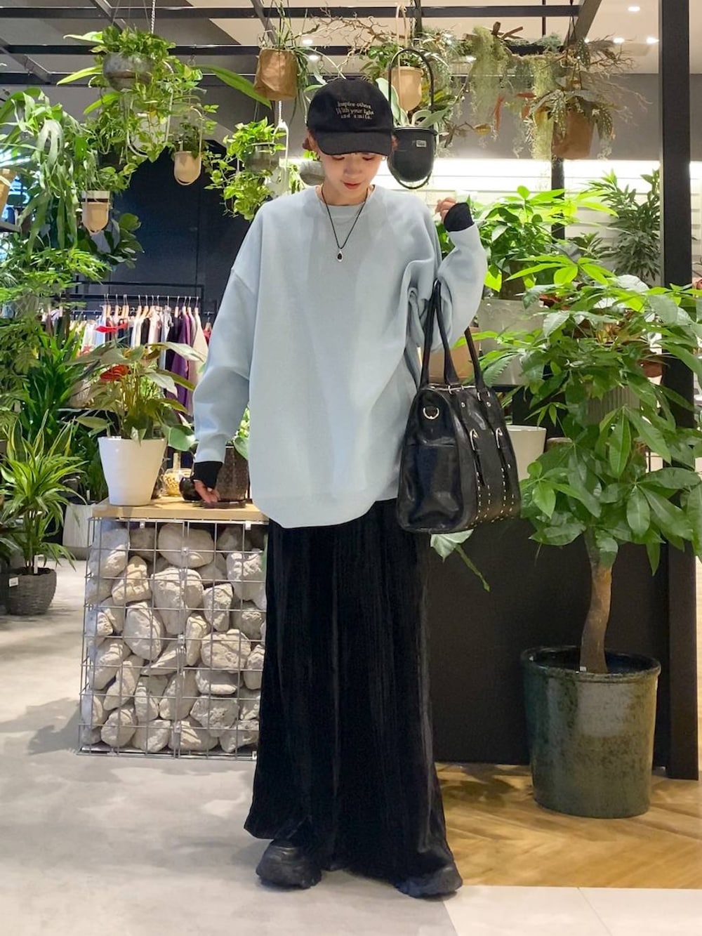 ブラック系のTシャツ/カットソー、ブルー系のニット/セーター、ブラック系のトートバッグを着用したレディースの秋コーディネートの5枚目の写真