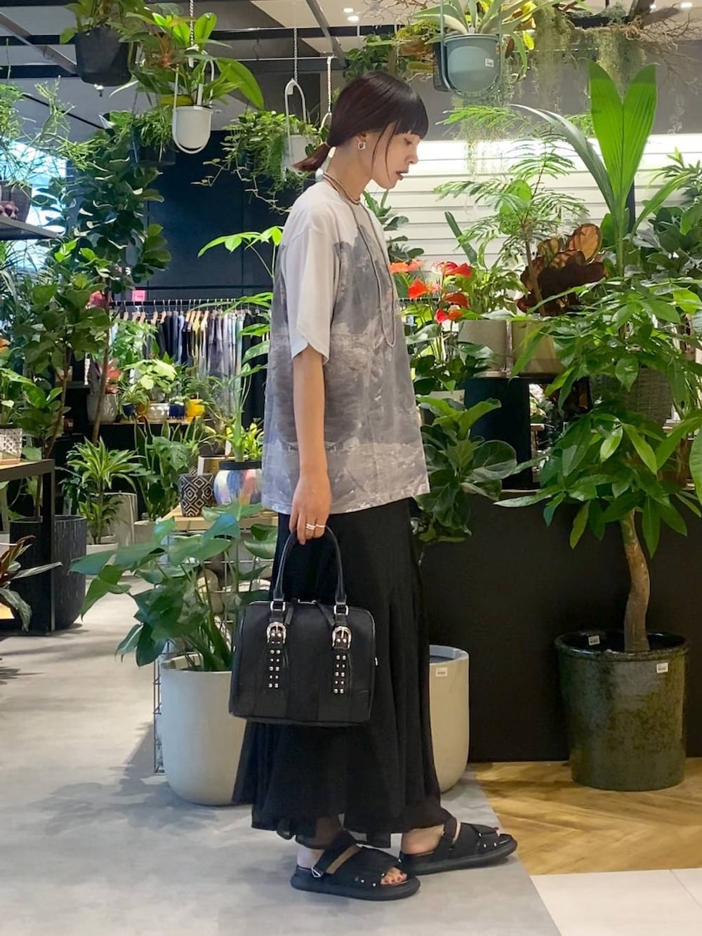 ブラック系のサンダル、グレー系のTシャツ/カットソー、ブラック系のスカートを着用したレディースの夏コーディネートの2枚目の写真