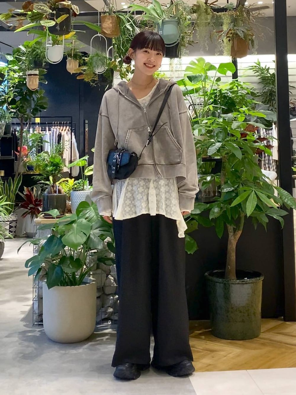 グレー系のパーカー、ブラック系のローファー、ブラック系のショルダーバッグを着用したレディースの夏コーディネートの3枚目の写真