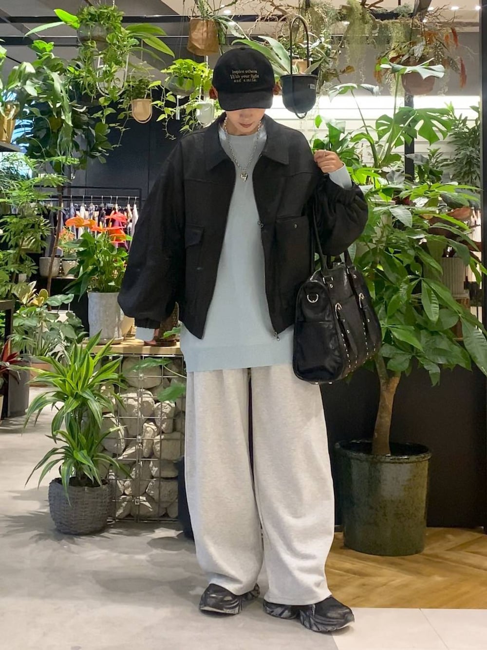 ブルー系のニット/セーター、ブラック系のブルゾン、ブラック系のスニーカーを着用したレディースの秋コーディネートの5枚目の写真