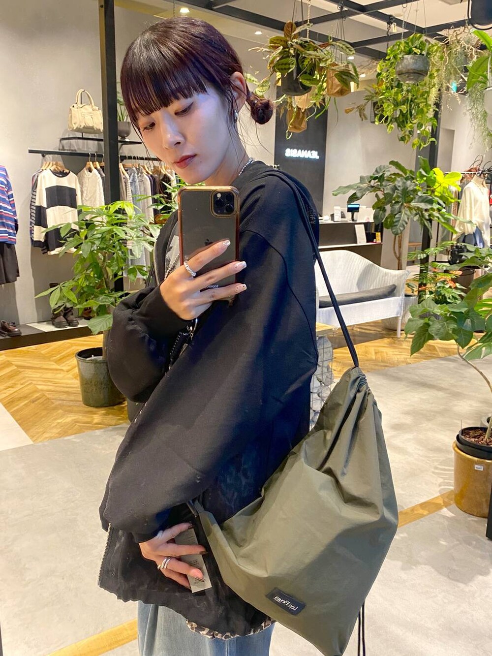 ブルー系のデニムパンツ、ブラック系のパーカー、ブラック系のスニーカーを着用したレディースの秋コーディネートの4枚目の写真