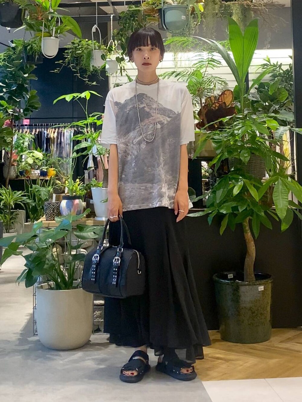 ブラック系のサンダル、グレー系のTシャツ/カットソー、ブラック系のスカートを着用したレディースの夏コーディネートの5枚目の写真
