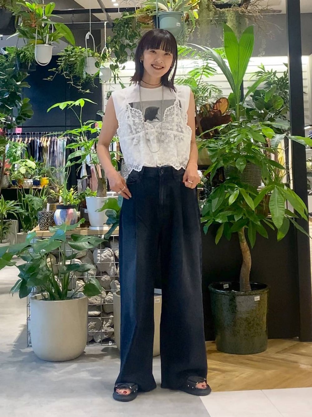 ベージュ系のショルダーバッグ、ブラック系のデニムパンツ、ブラック系のサンダルを着用したレディースの夏コーディネートの4枚目の写真