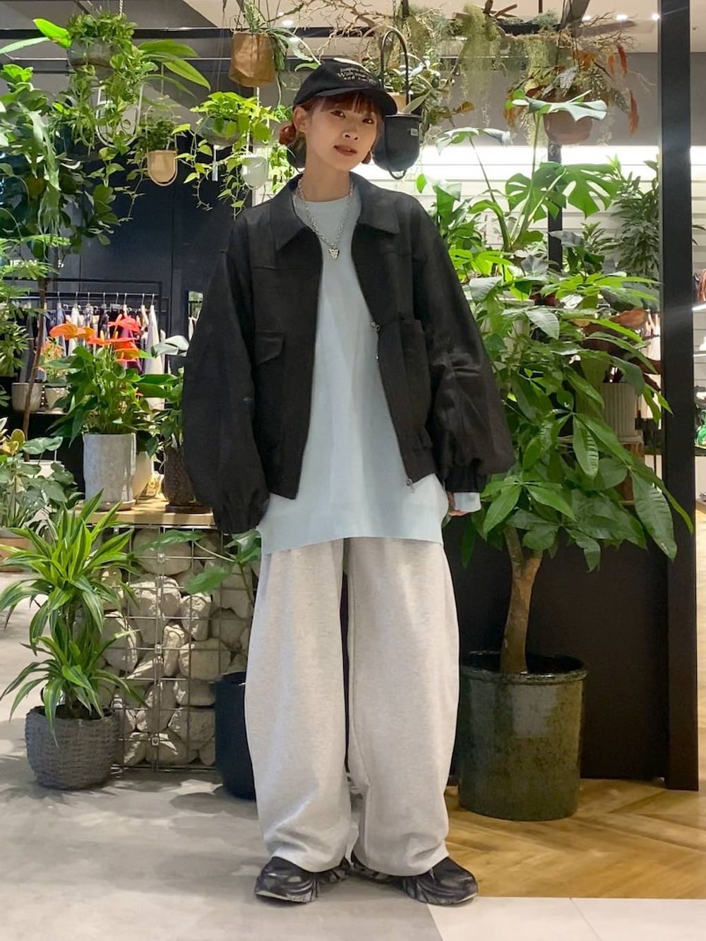 ブルー系のニット/セーター、ブラック系のブルゾン、ブラック系のスニーカーを着用したレディースの秋コーディネートの3枚目の写真