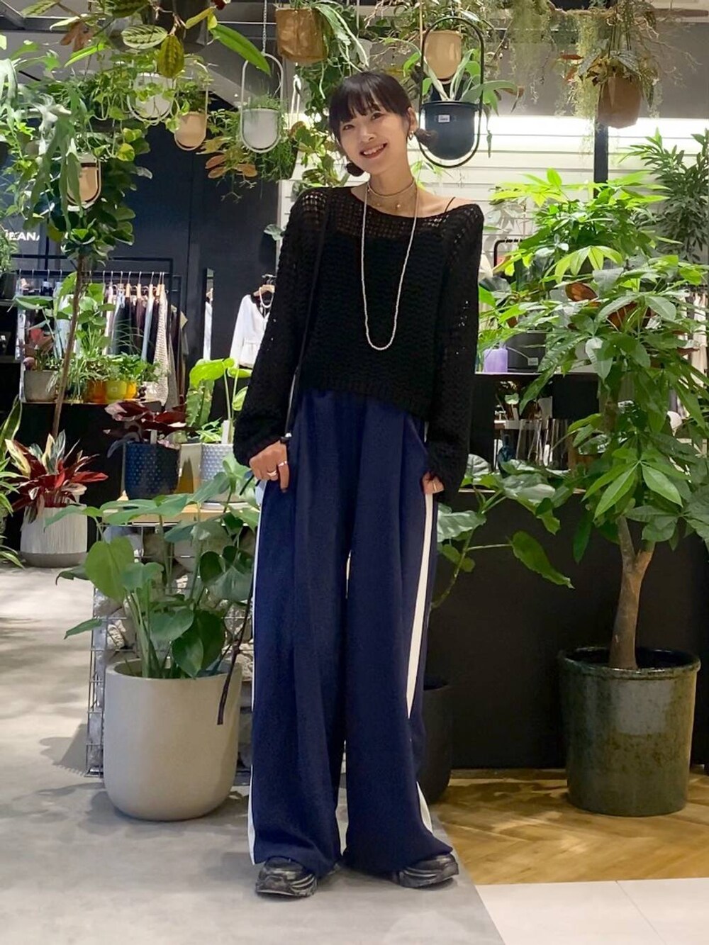 ブラック系のスニーカー、ブラック系のニット/セーター、ブルー系のその他パンツを着用したレディースの秋コーディネートの5枚目の写真