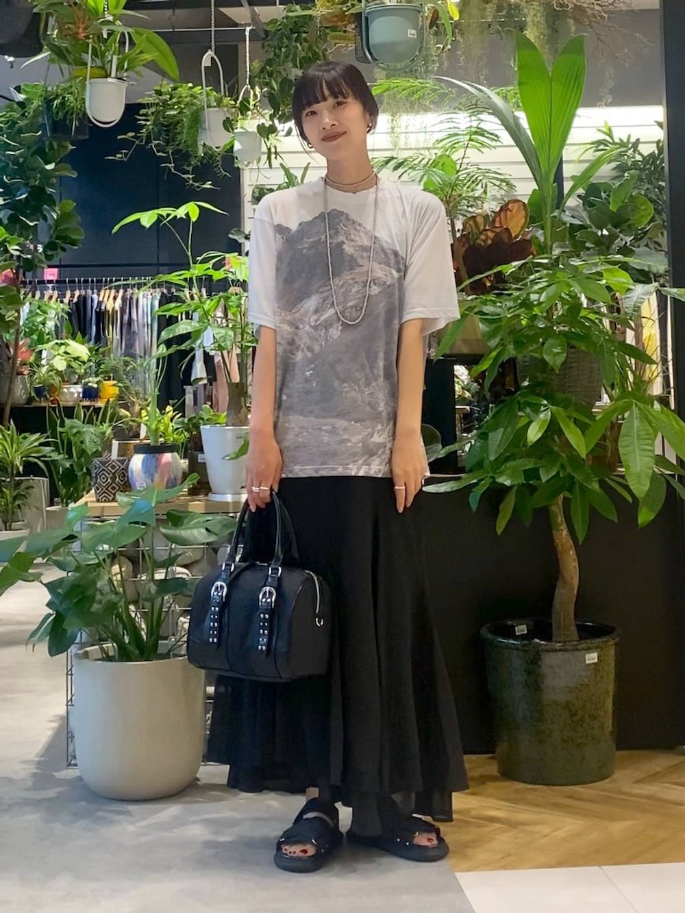 ブラック系のサンダル、グレー系のTシャツ/カットソー、ブラック系のスカートを着用したレディースの夏コーディネートの3枚目の写真