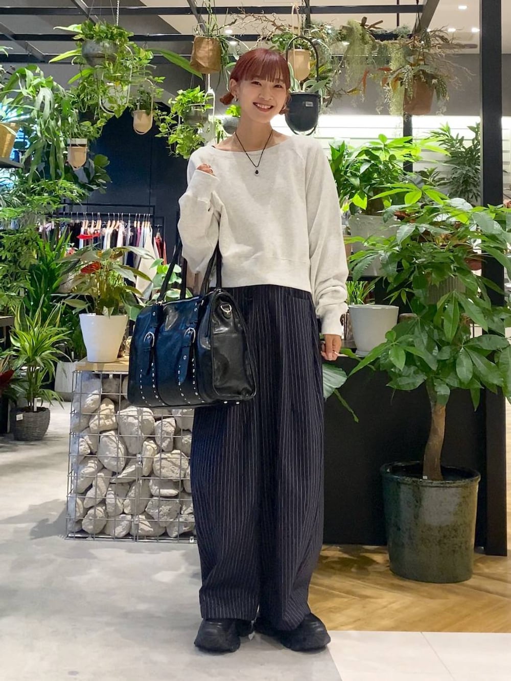 ブラック系のローファー、ブルー系のスラックス、ブラック系のトートバッグを着用したレディースの秋コーディネートの6枚目の写真