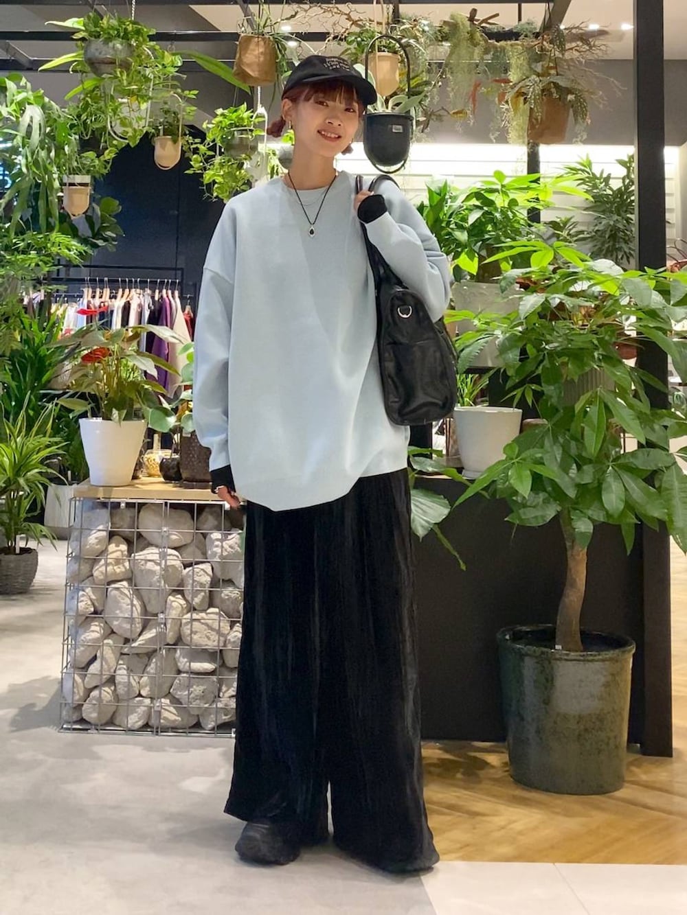 ブラック系のTシャツ/カットソー、ブルー系のニット/セーター、ブラック系のトートバッグを着用したレディースの秋コーディネートの3枚目の写真