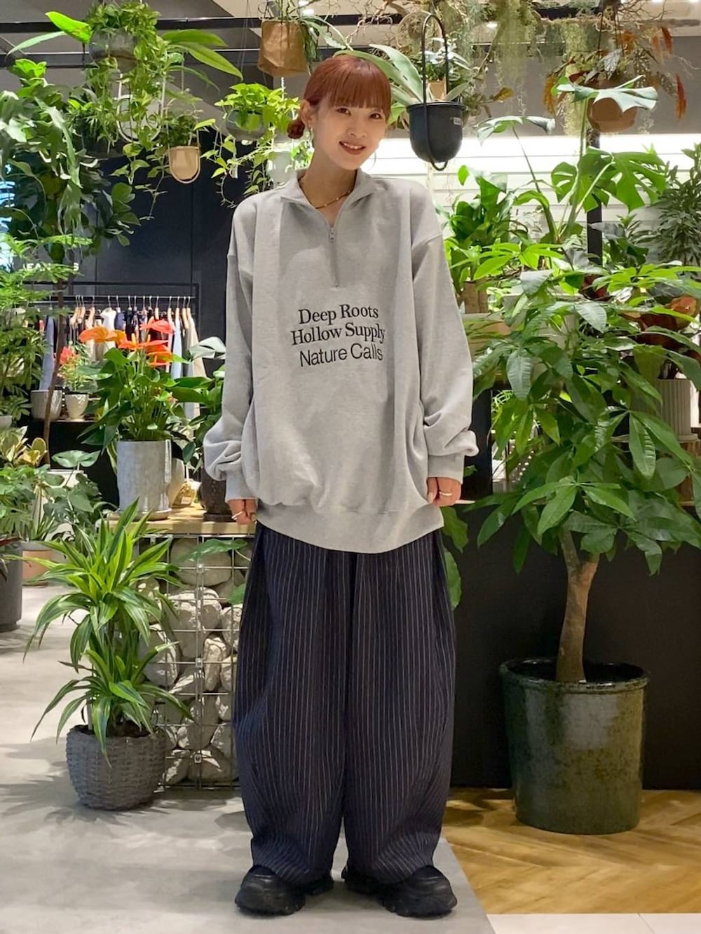 ブラック系のショルダーバッグ、ブラック系のローファー、ブルー系のスラックスを着用したレディースの秋コーディネートの3枚目の写真