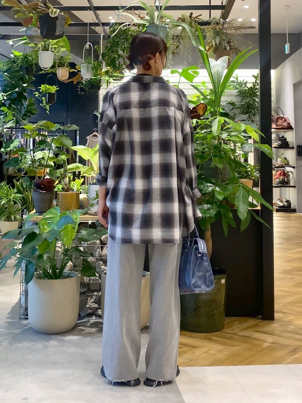 グレー系のシャツ/ブラウス、ブルー系のボストンバッグ、グレー系のデニムパンツを着用したレディースの夏コーディネートの4枚目の写真