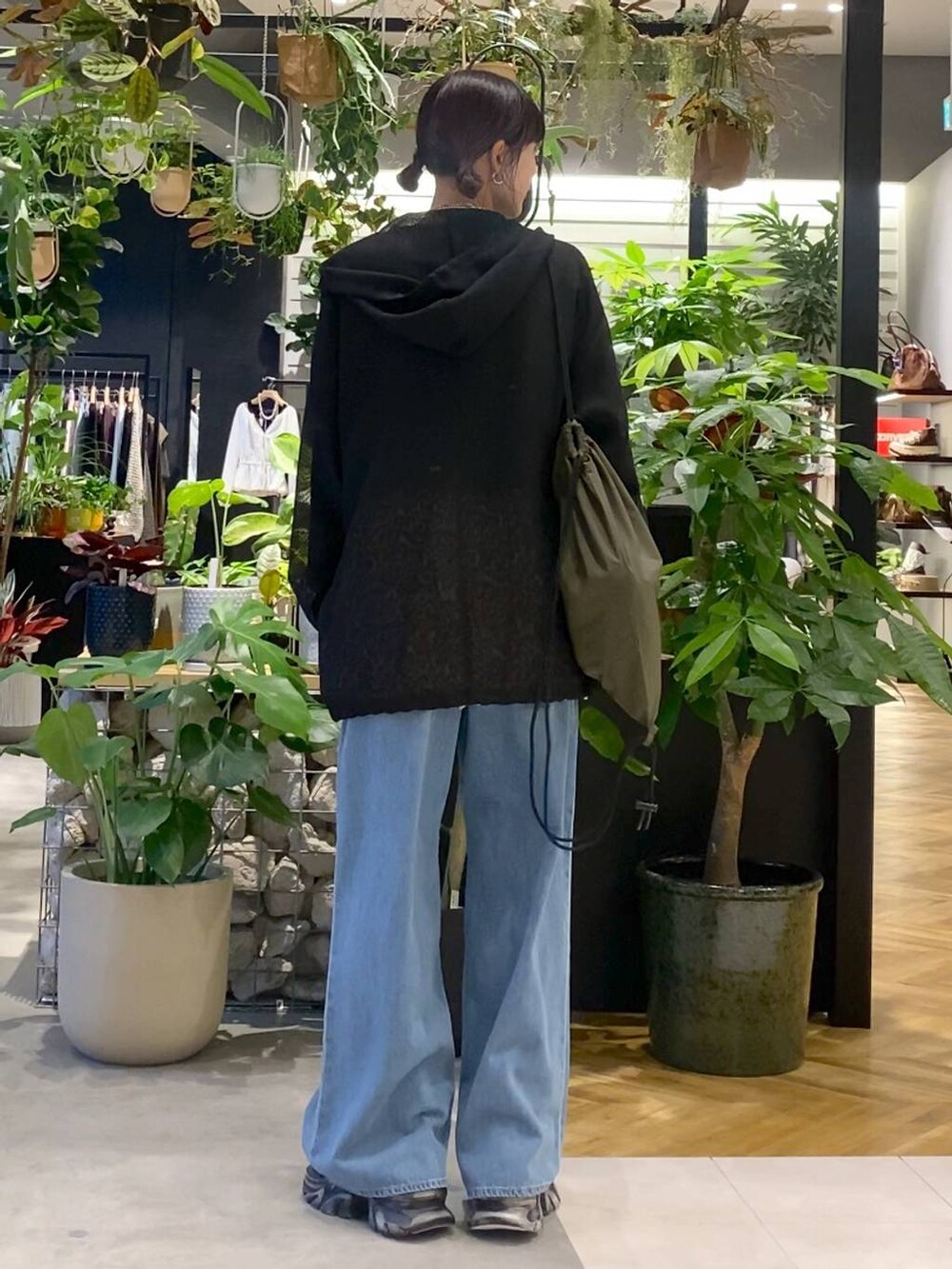 ブルー系のデニムパンツ、ブラック系のパーカー、ブラック系のスニーカーを着用したレディースの秋コーディネートの5枚目の写真