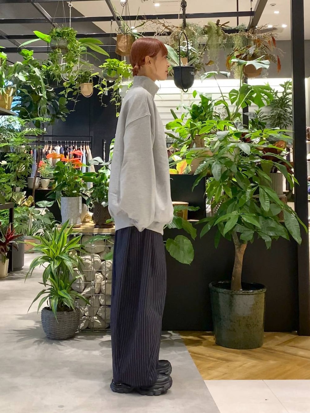 ブラック系のショルダーバッグ、ブラック系のローファー、ブルー系のスラックスを着用したレディースの秋コーディネートの2枚目の写真