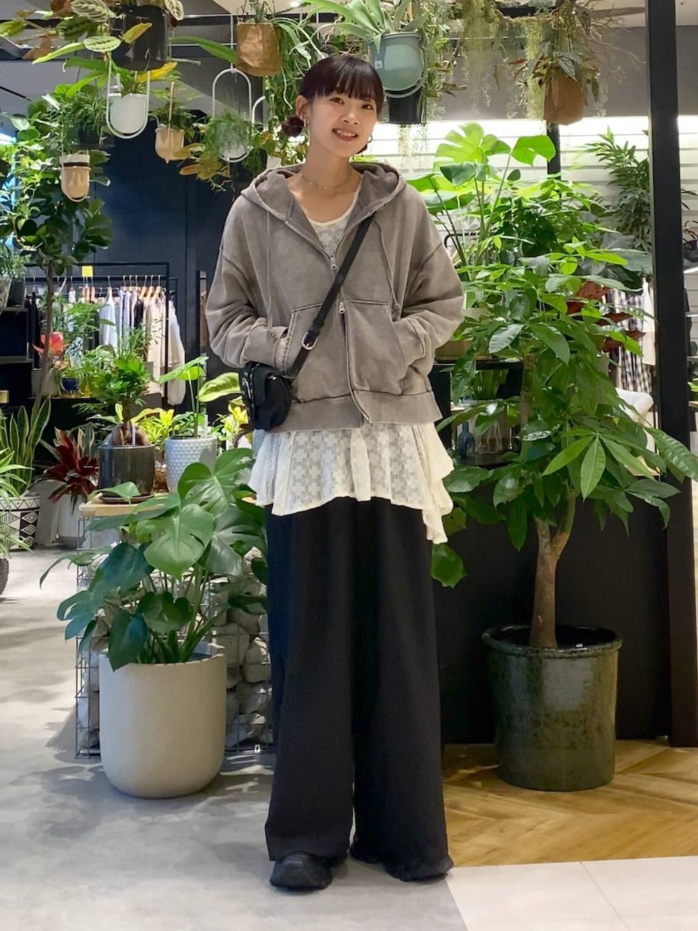 グレー系のパーカー、ブラック系のローファー、ブラック系のショルダーバッグを着用したレディースの夏コーディネートの5枚目の写真