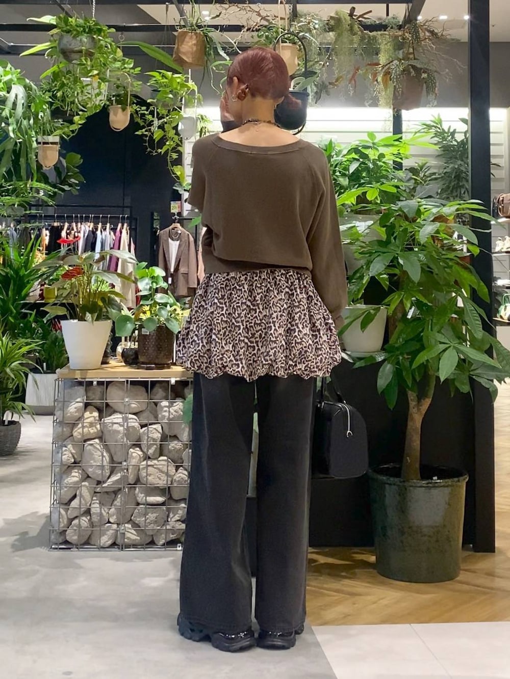 グレー系のデニムパンツ、ブラック系のローファー、ブラック系のボストンバッグを着用したレディースの秋コーディネートの4枚目の写真