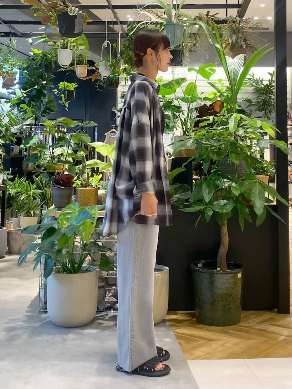 グレー系のシャツ/ブラウス、ブルー系のボストンバッグ、グレー系のデニムパンツを着用したレディースの夏コーディネートの2枚目の写真