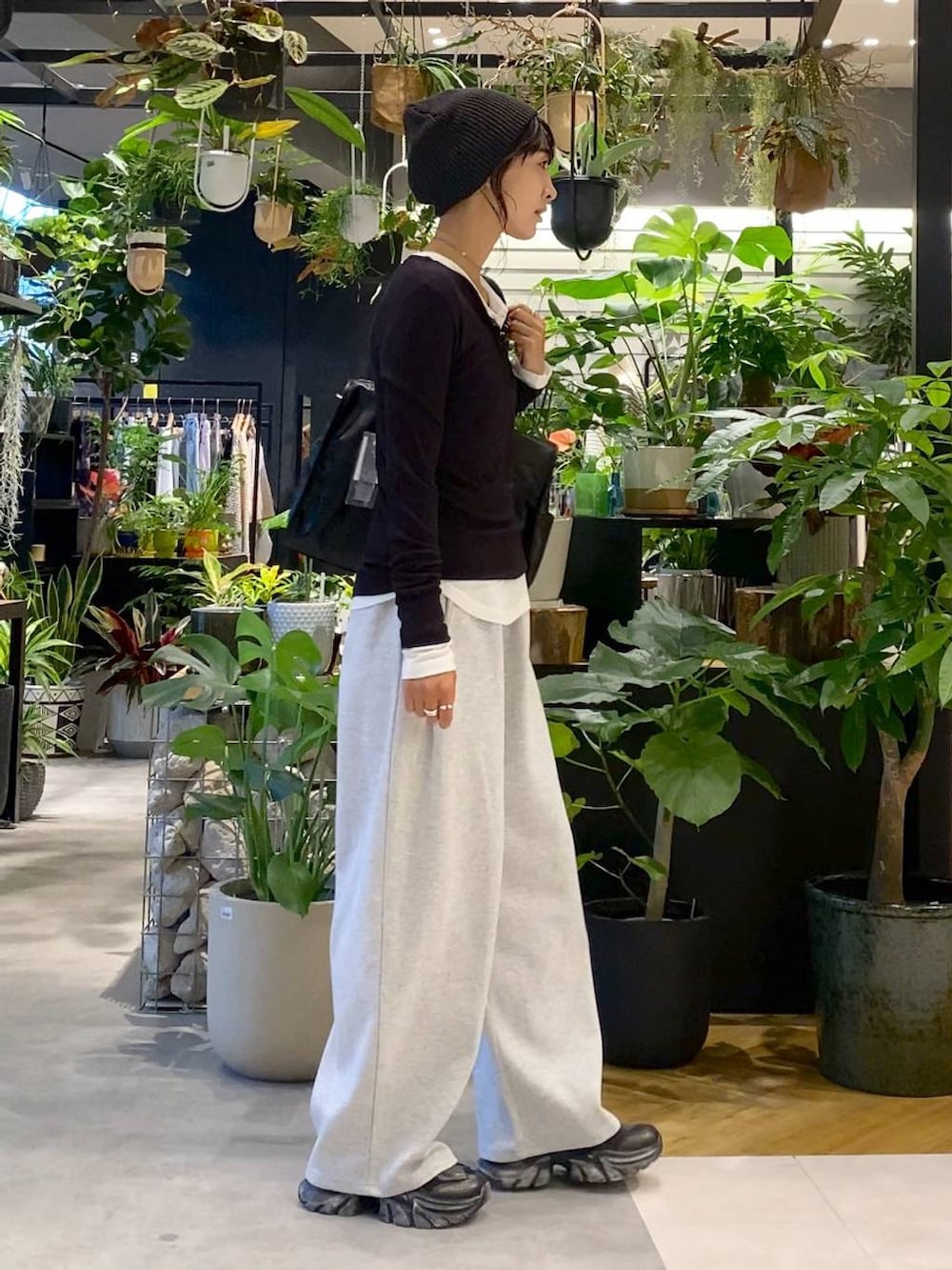 ブラック系のスニーカー、グレー系のスウェットパンツ、ブラック系のトートバッグを着用したレディースの夏コーディネートの2枚目の写真