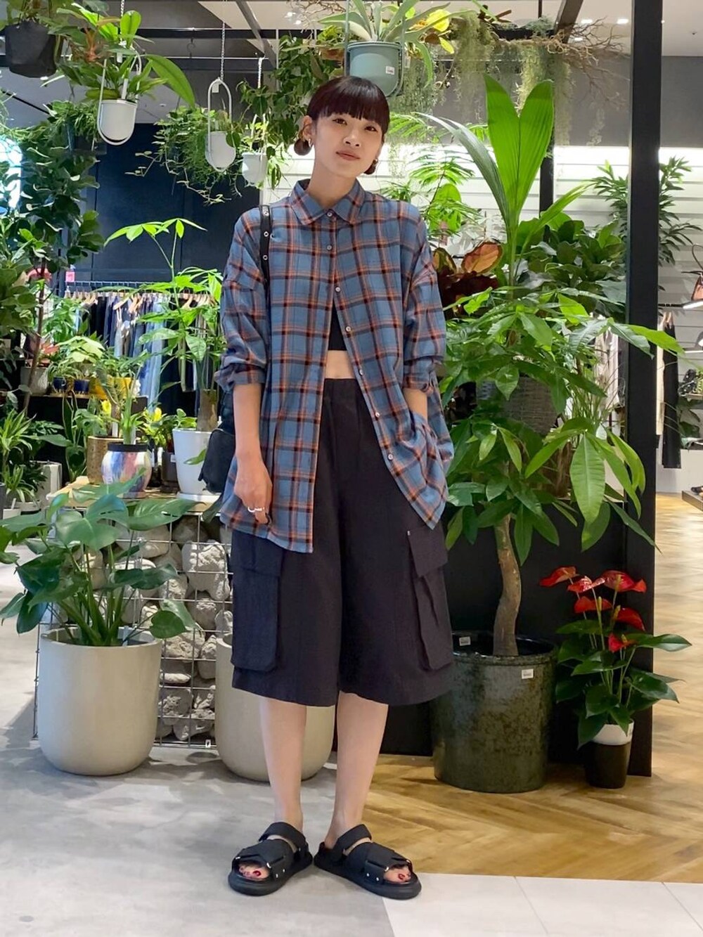 ブルー系のシャツ/ブラウス、ブラック系のタンクトップ、ブラック系のショルダーバッグを着用したレディースの夏コーディネートの4枚目の写真