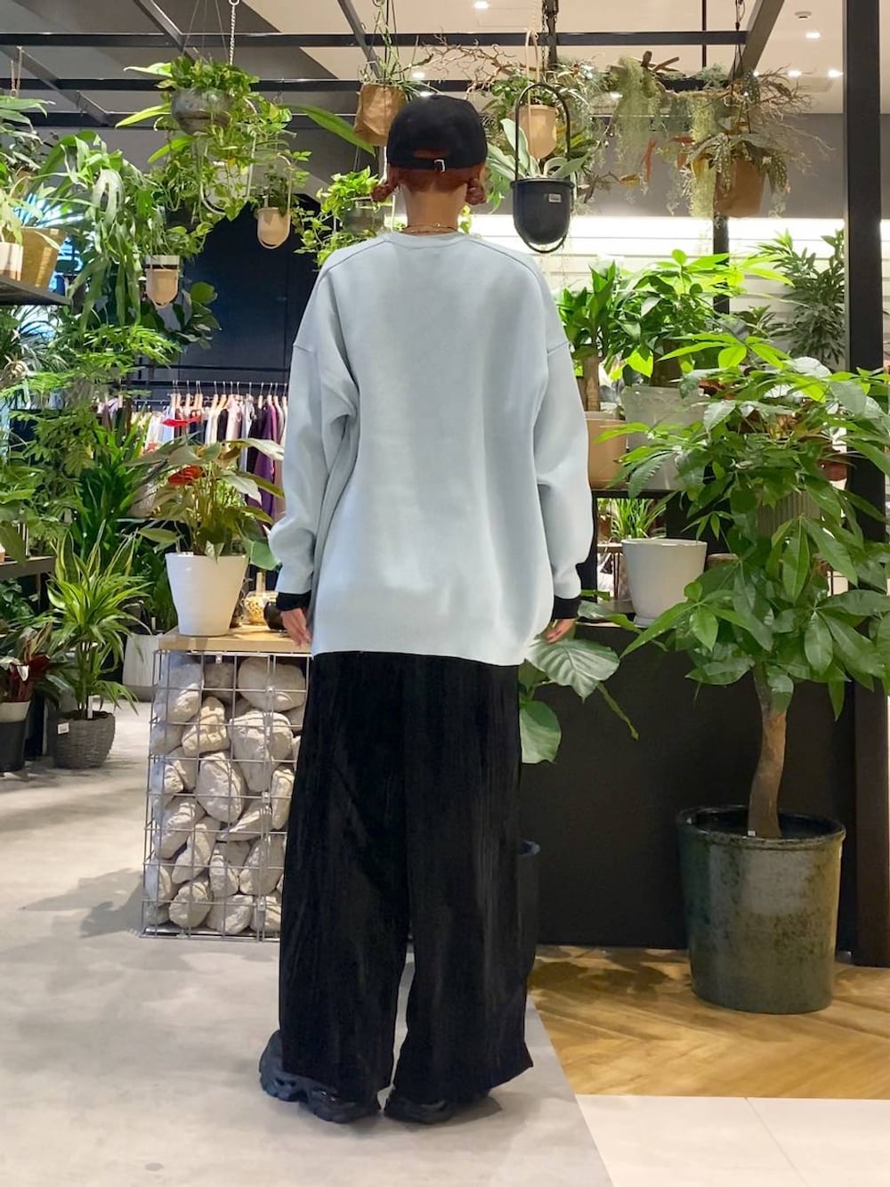 ブラック系のTシャツ/カットソー、ブルー系のニット/セーター、ブラック系のトートバッグを着用したレディースの秋コーディネートの4枚目の写真