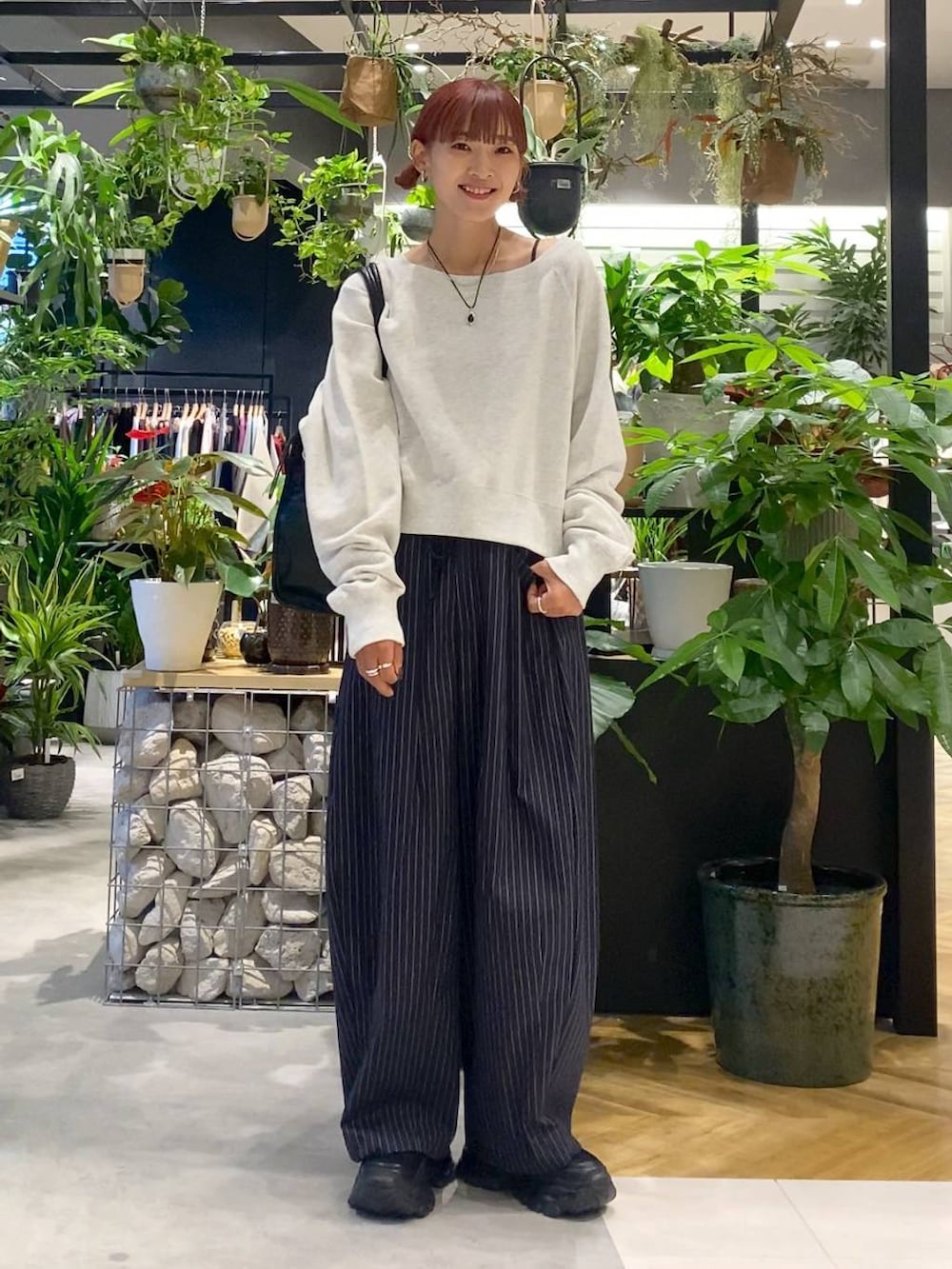 ブラック系のローファー、ブルー系のスラックス、ブラック系のトートバッグを着用したレディースの秋コーディネートの3枚目の写真