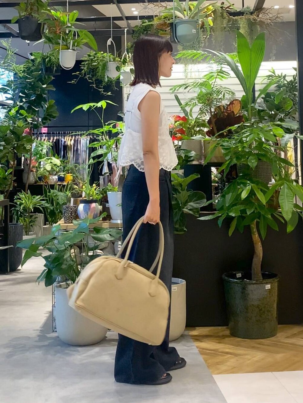 ベージュ系のショルダーバッグ、ブラック系のデニムパンツ、ブラック系のサンダルを着用したレディースの夏コーディネートの3枚目の写真