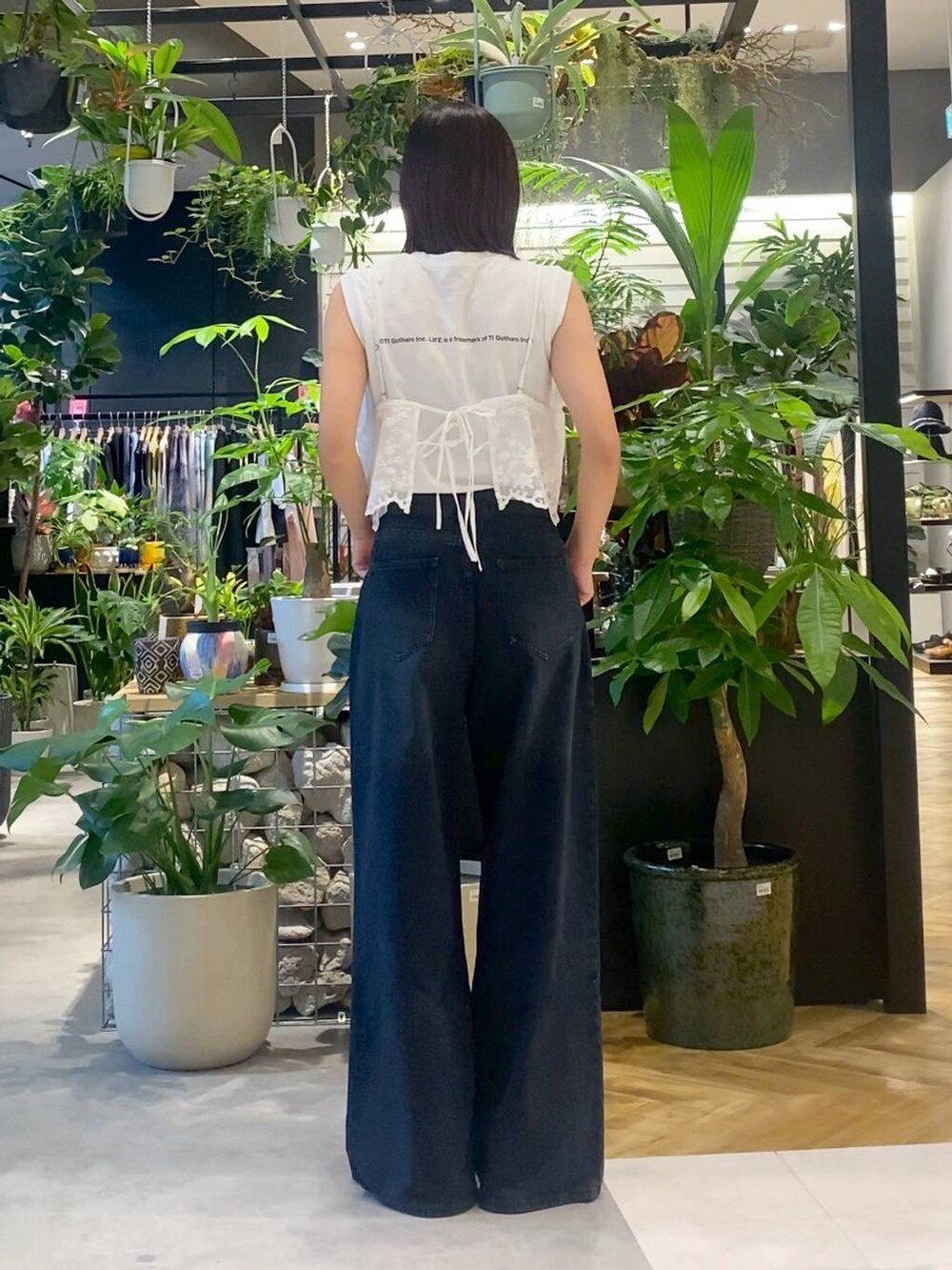 ベージュ系のショルダーバッグ、ブラック系のデニムパンツ、ブラック系のサンダルを着用したレディースの夏コーディネートの5枚目の写真