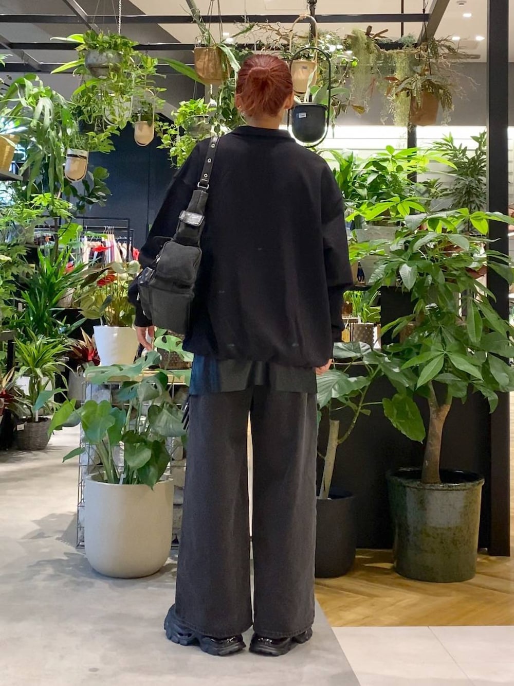 ブラック系のデニムパンツ、ブラック系のショルダーバッグ、ブラック系のローファーを着用したレディースの秋コーディネートの3枚目の写真