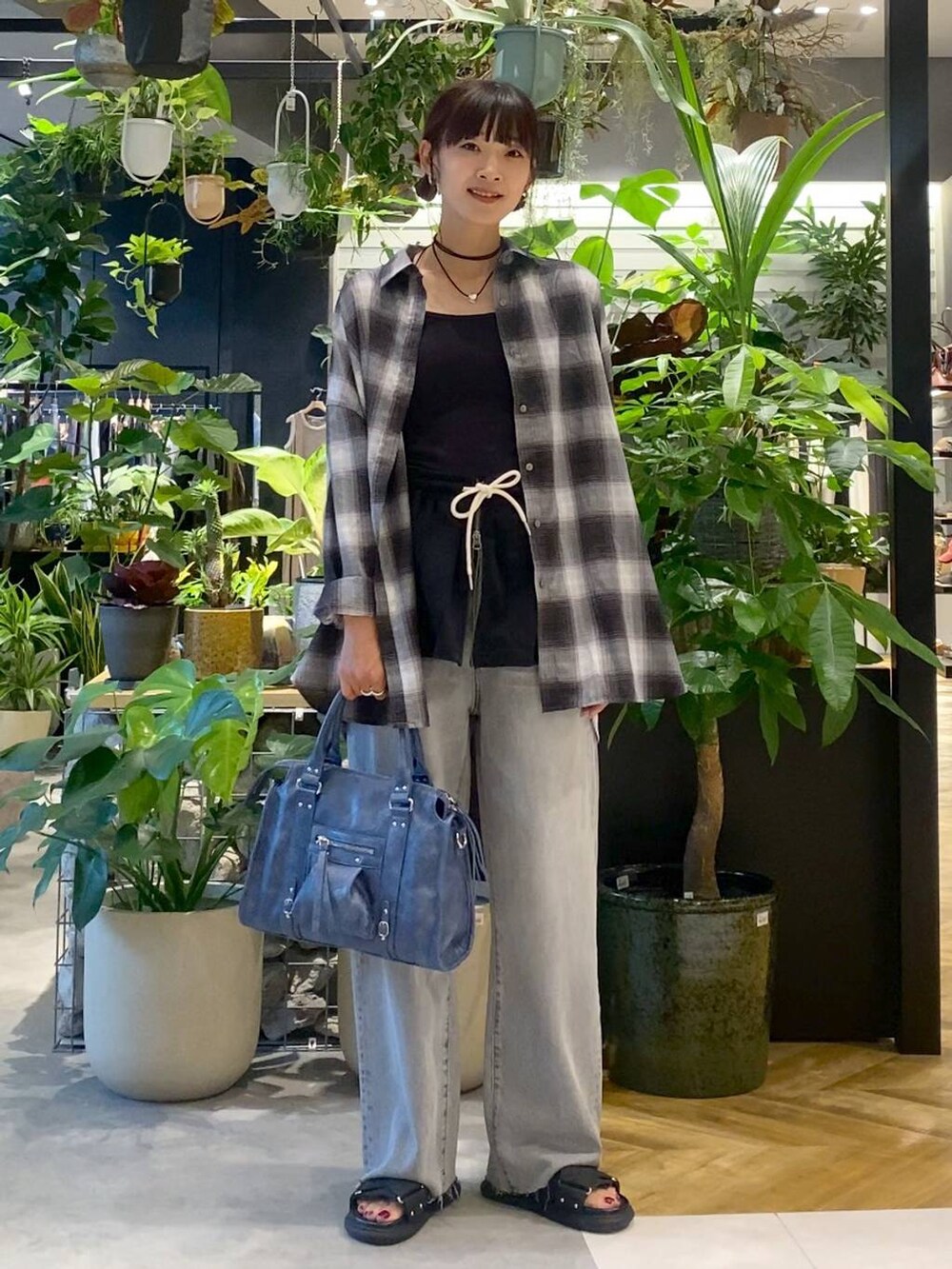 グレー系のシャツ/ブラウス、ブルー系のボストンバッグ、グレー系のデニムパンツを着用したレディースの夏コーディネートの3枚目の写真