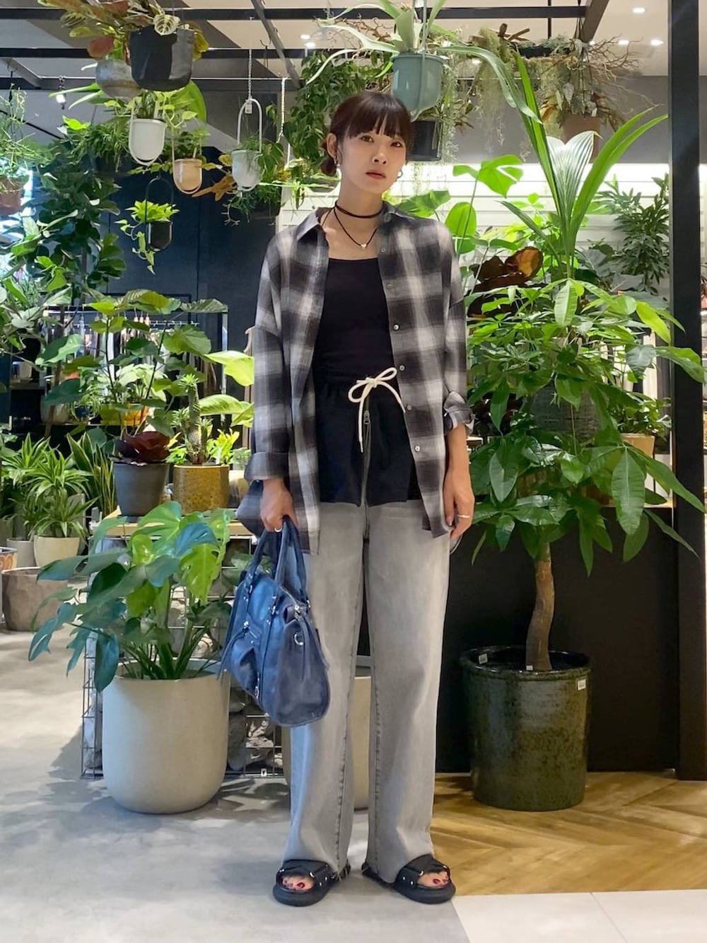 グレー系のシャツ/ブラウス、ブルー系のボストンバッグ、グレー系のデニムパンツを着用したレディースの夏コーディネートの5枚目の写真