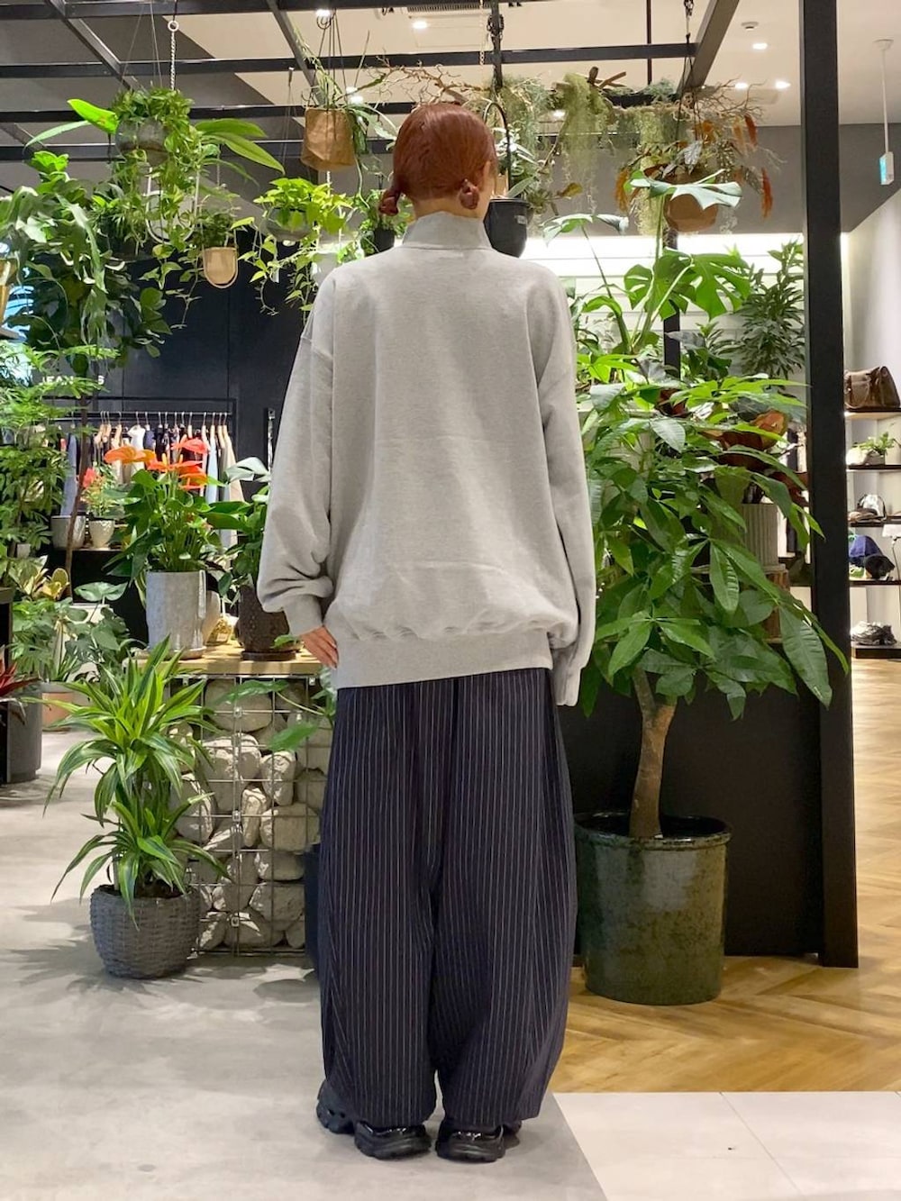 ブラック系のショルダーバッグ、ブラック系のローファー、ブルー系のスラックスを着用したレディースの秋コーディネートの4枚目の写真