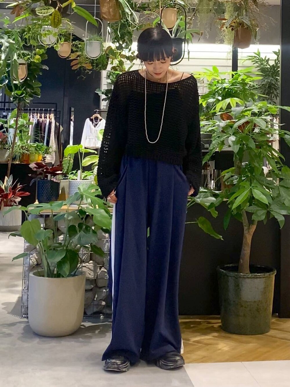 ブラック系のスニーカー、ブラック系のニット/セーター、ブルー系のその他パンツを着用したレディースの秋コーディネートの3枚目の写真