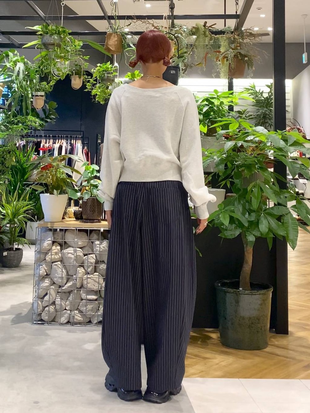 ブラック系のローファー、ブルー系のスラックス、ブラック系のトートバッグを着用したレディースの秋コーディネートの4枚目の写真