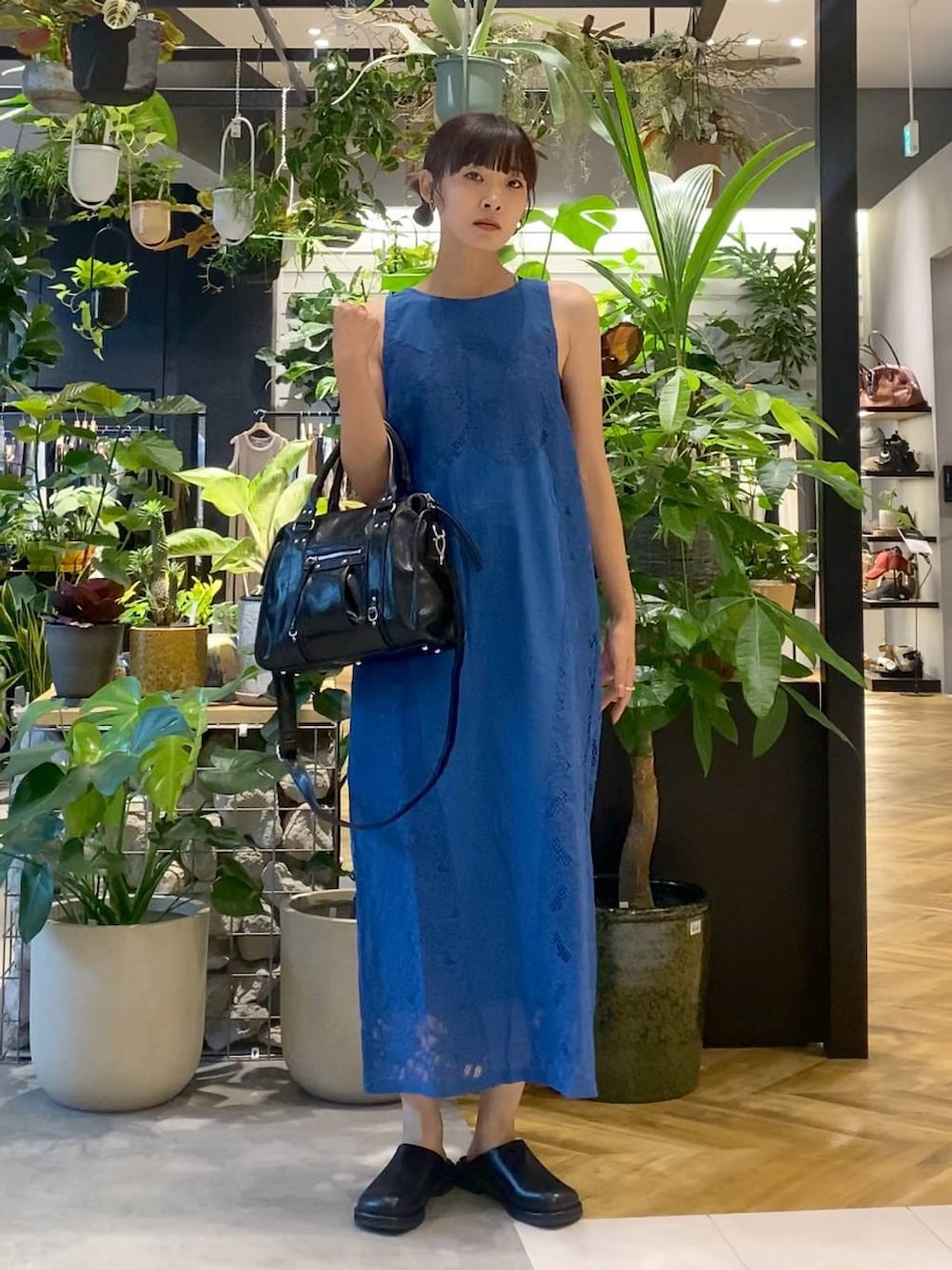 ブラック系のボストンバッグ、ブルー系のワンピース、ブラック系のサンダルを着用したレディースの夏コーディネートの5枚目の写真