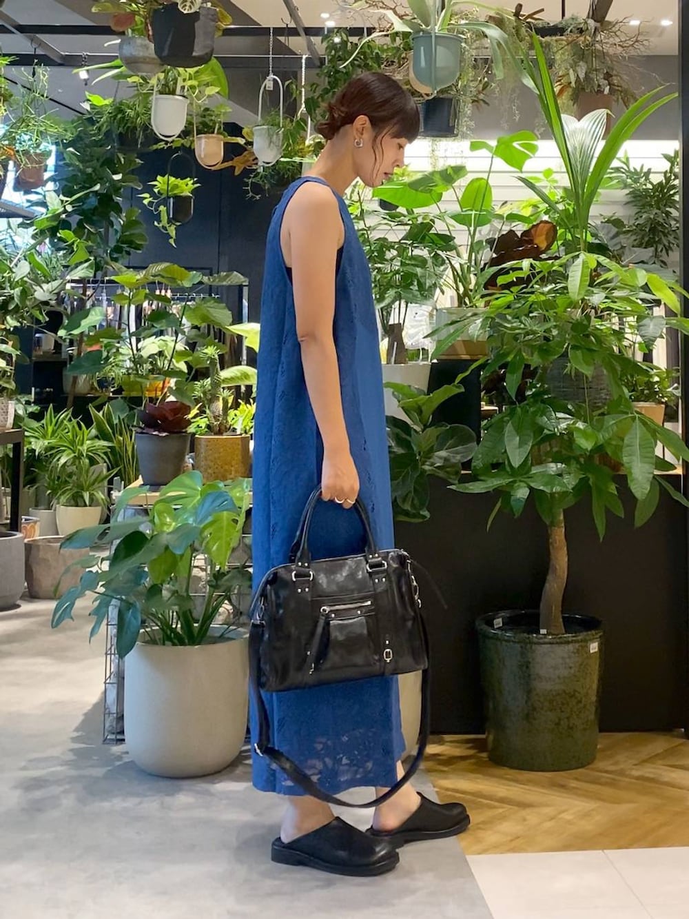 ブラック系のボストンバッグ、ブルー系のワンピース、ブラック系のサンダルを着用したレディースの夏コーディネートの2枚目の写真