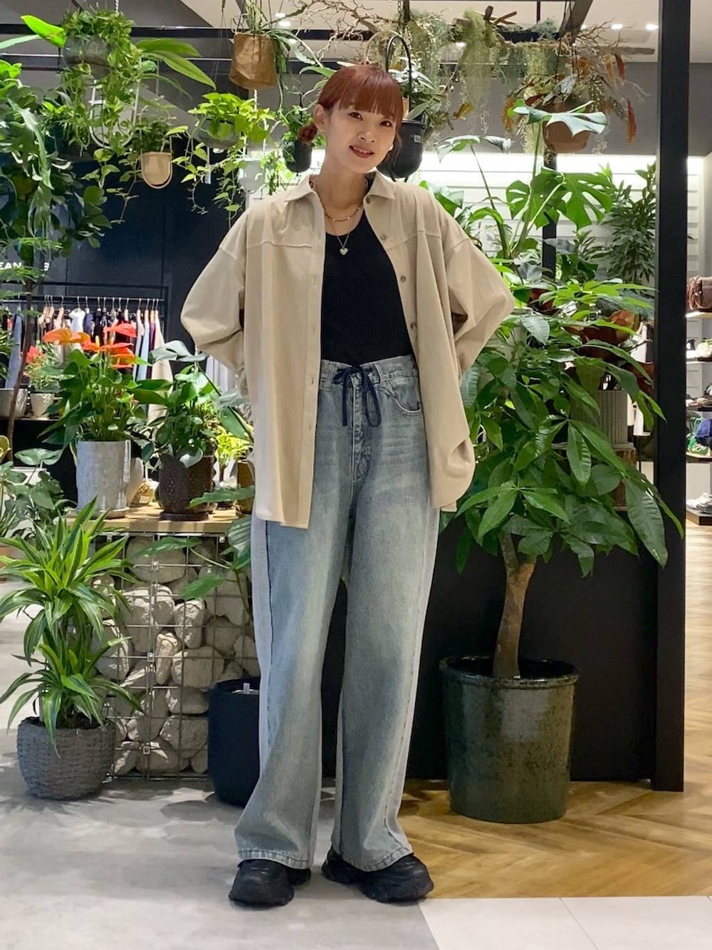 ブラック系のローファー、ブルー系のデニムパンツ、ブラック系のボストンバッグを着用したレディースの秋コーディネートの3枚目の写真