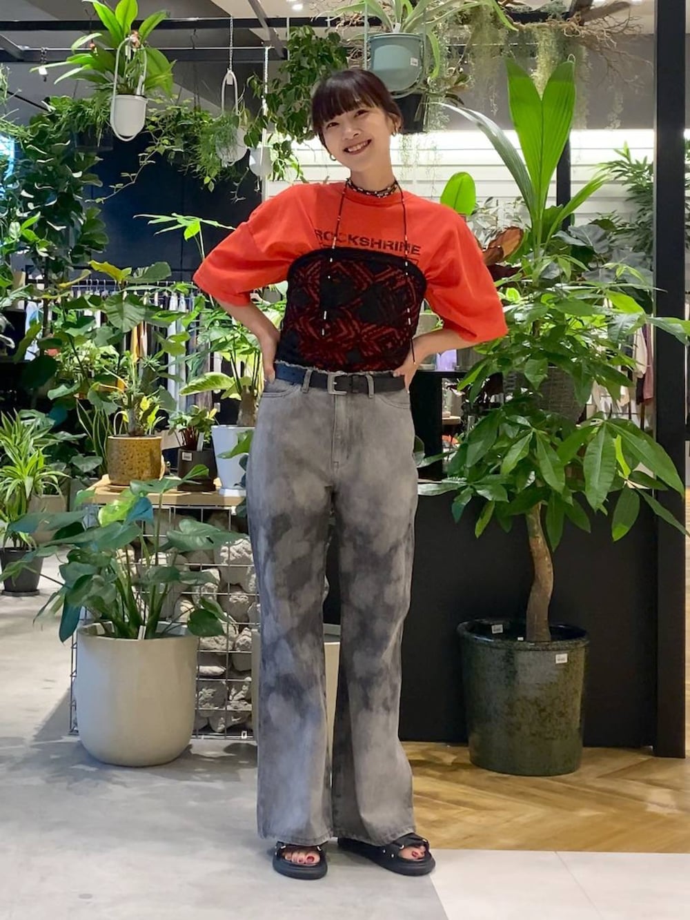 ブラック系のサンダル、ブラック系のボストンバッグ、グレー系のデニムパンツを着用したレディースの夏コーディネートの5枚目の写真