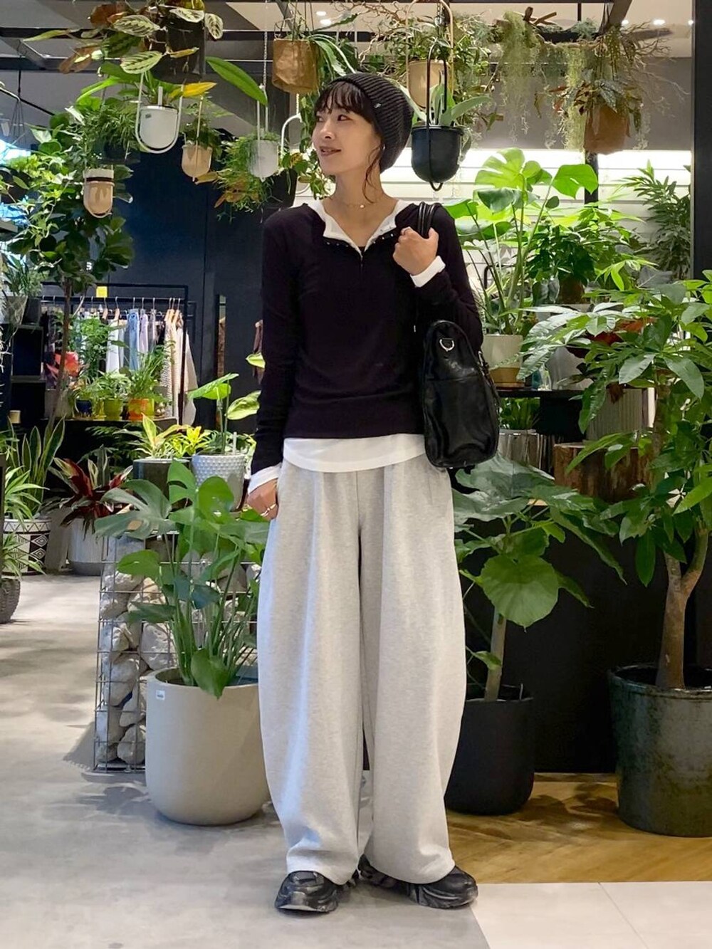 ブラック系のスニーカー、グレー系のスウェットパンツ、ブラック系のトートバッグを着用したレディースの夏コーディネートの3枚目の写真