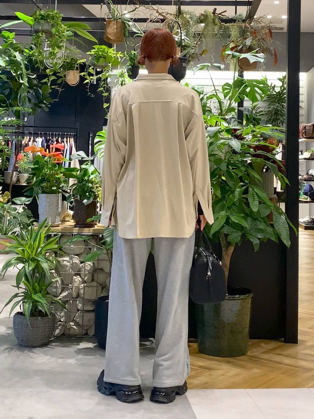 ブラック系のローファー、ブルー系のデニムパンツ、ブラック系のボストンバッグを着用したレディースの秋コーディネートの4枚目の写真