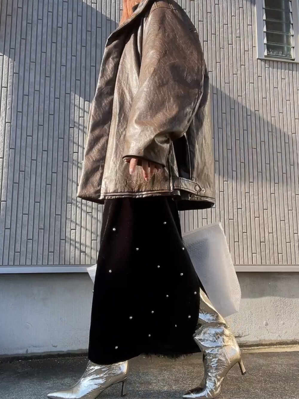 ブラウン系のその他アウター、ホワイト系のニット/セーター、ブラック系のスカートを着用したレディースの冬コーディネートの2枚目の写真