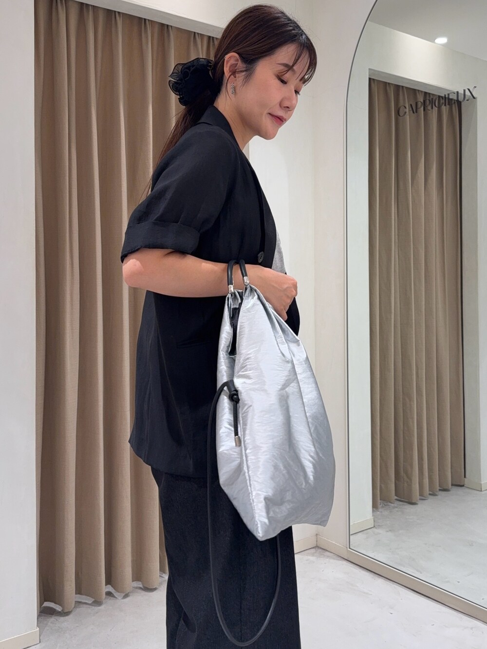 ブラック系のテーラードジャケット、グレー系のTシャツ/カットソー、シルバー系のショルダーバッグを着用したレディースの夏コーディネートの5枚目の写真