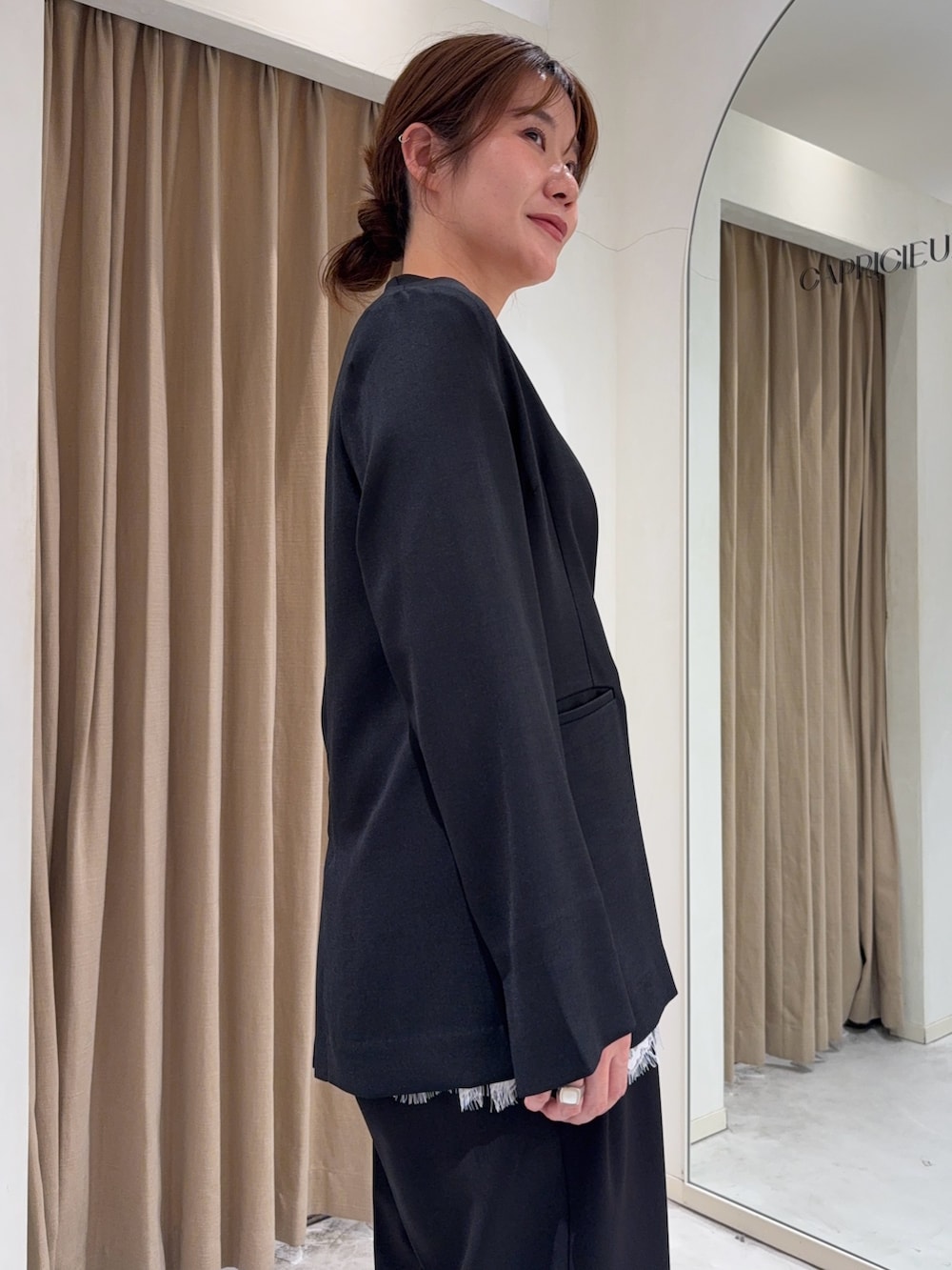 ブラック系のトップス、ホワイト系のキャミソール、ホワイト系のショルダーバッグを着用したレディースの春コーディネートの5枚目の写真