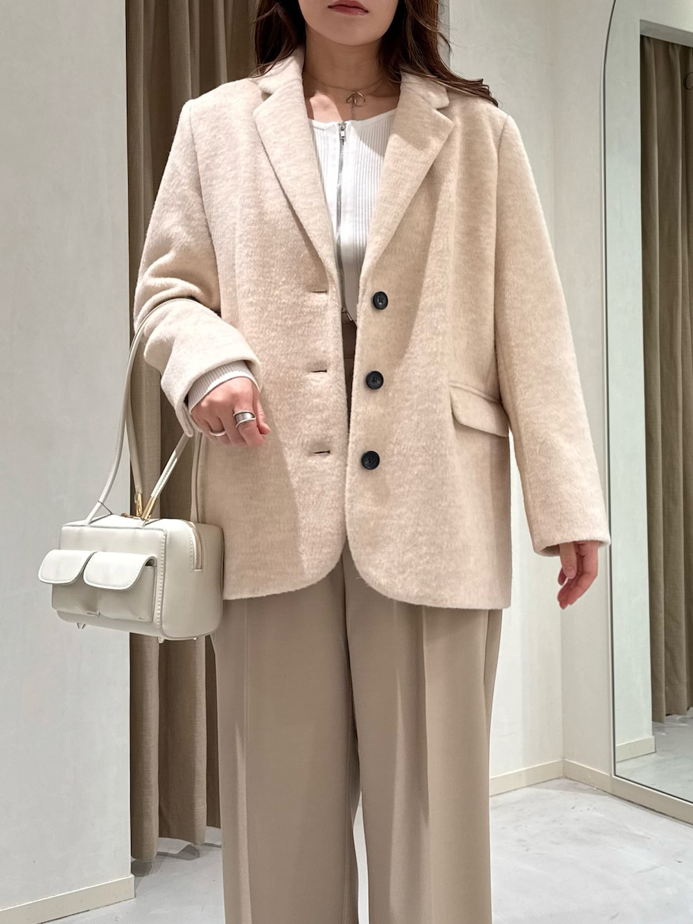 ベージュ系のテーラードジャケット、ホワイト系のニット/セーター、ベージュ系のその他パンツを着用したレディースの冬コーディネートの3枚目の写真
