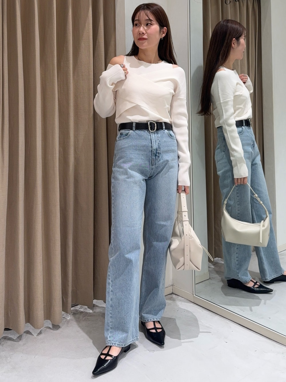 ホワイト系のニット/セーター、ブラック系のパンプス、ホワイト系のショルダーバッグを着用したレディースの冬コーディネートの4枚目の写真