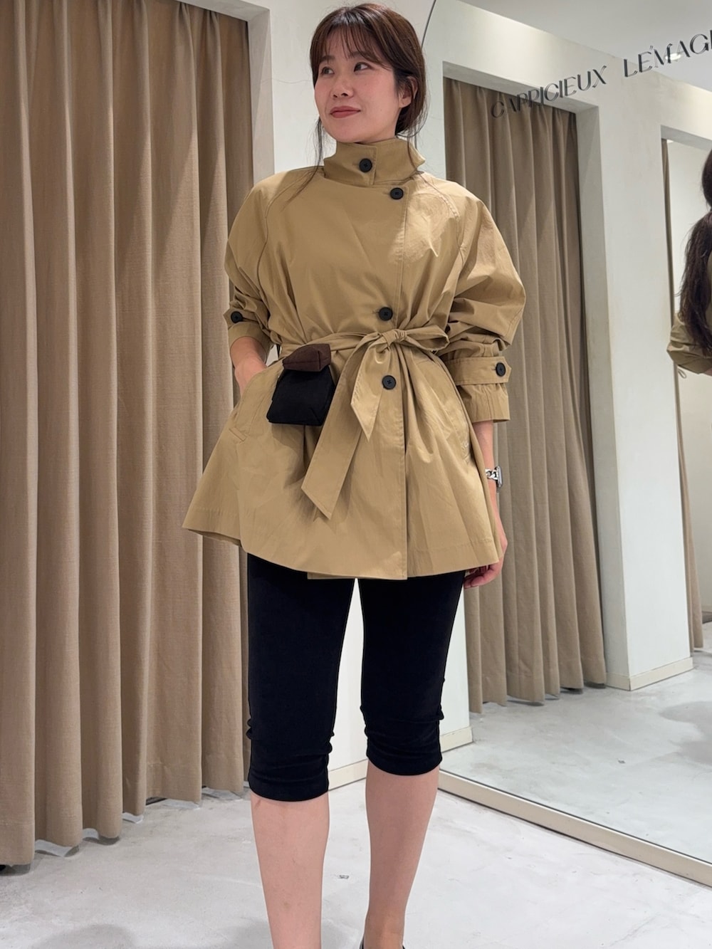ベージュ系のトレンチコート、ブラック系のその他パンツ、ブラック系のパンプスを着用したレディースの秋コーディネートの3枚目の写真